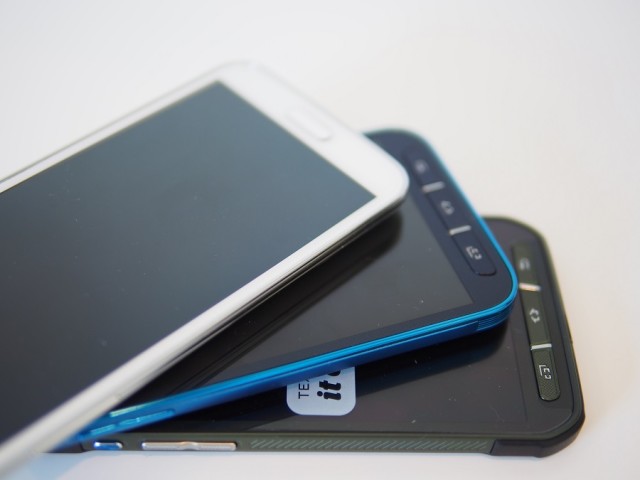 With rounded corners, the Galaxy S5 Sport (middle) feels more like the Galaxy S5 (top, white) than the Galaxy S5 Active on AT&T (bottom) with its more rugged appearance thanks to grippier edges and corner bumpers.